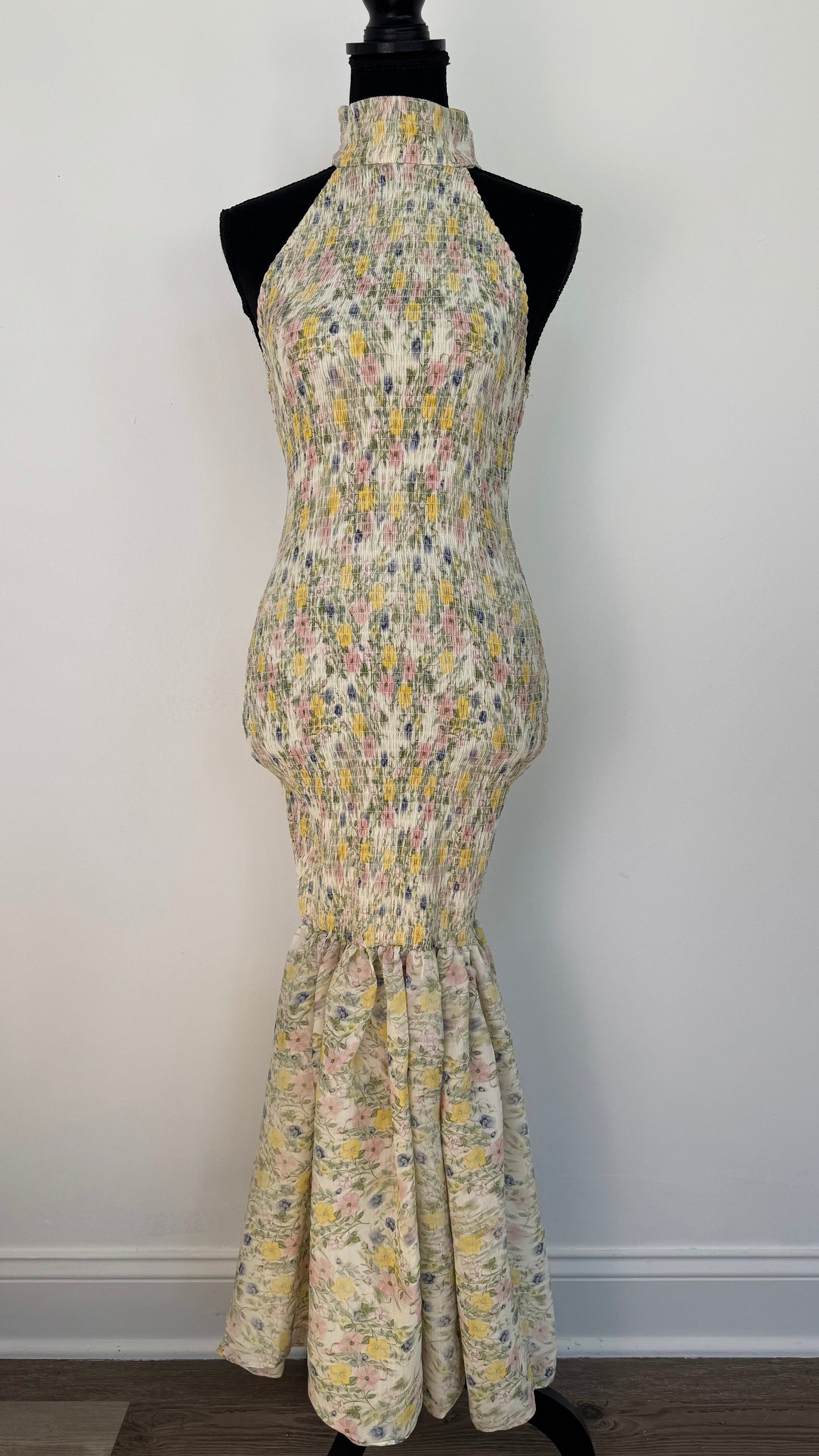 Front view of dress featuring a ruched fabric down to the knees and then changes to a delicate mermaid design made of light fabric.