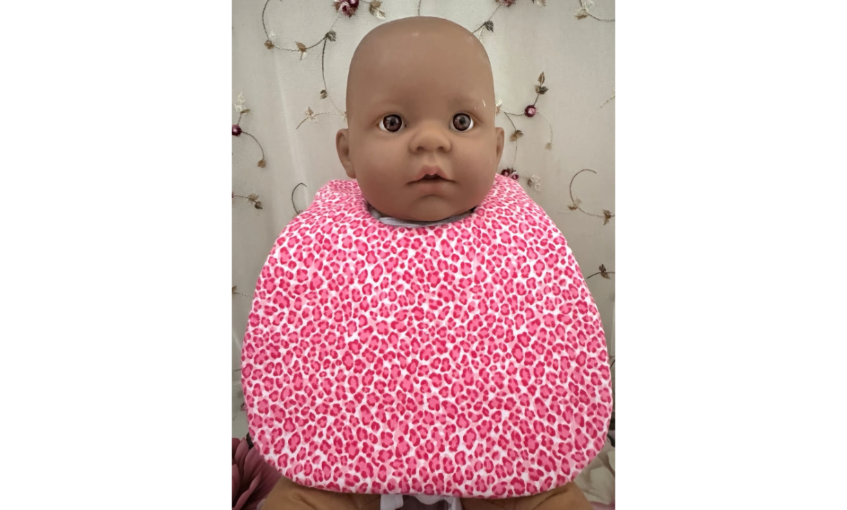 Baby wearing pink leopard print super absorbent bib.